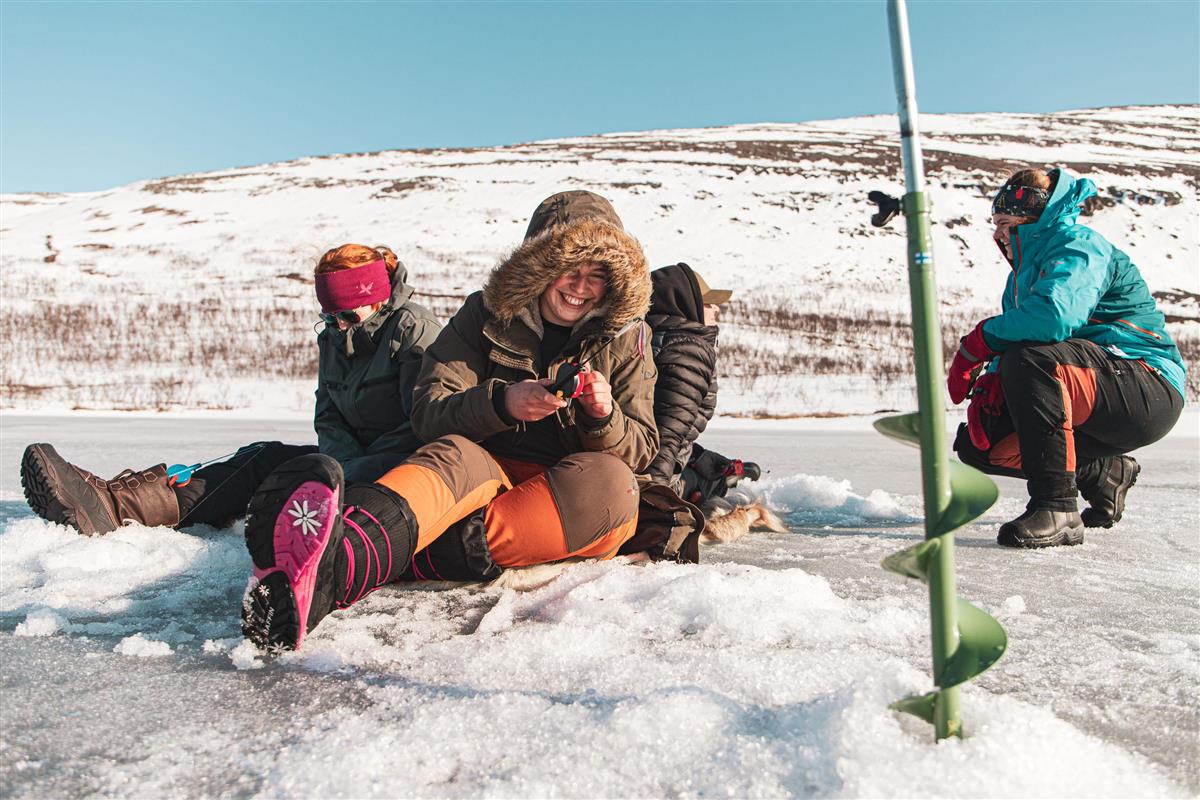 Glade elever koser seg med isfiske - Klikk for stort bilde